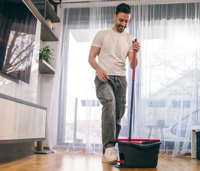 Person is mopping wooden floor for cleanliness.